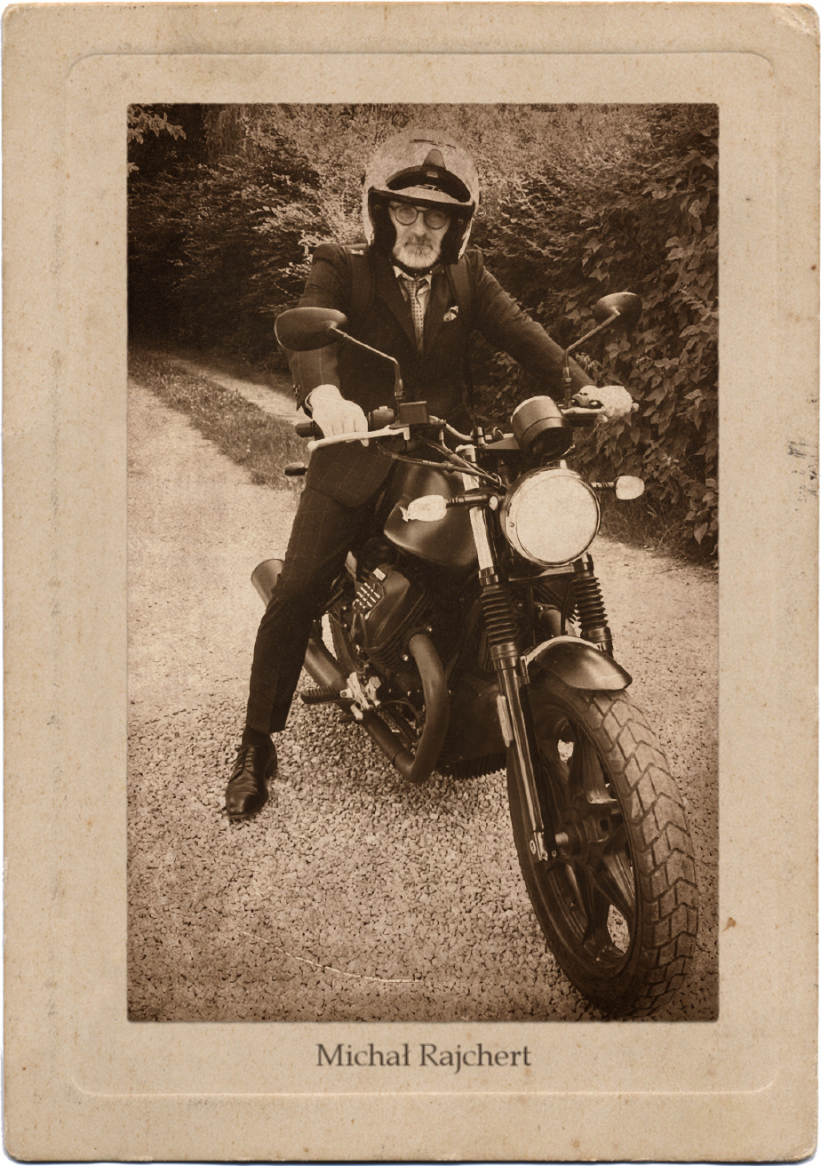 Mężczyzna w granatowym garniturze na czarnym motocyklu.