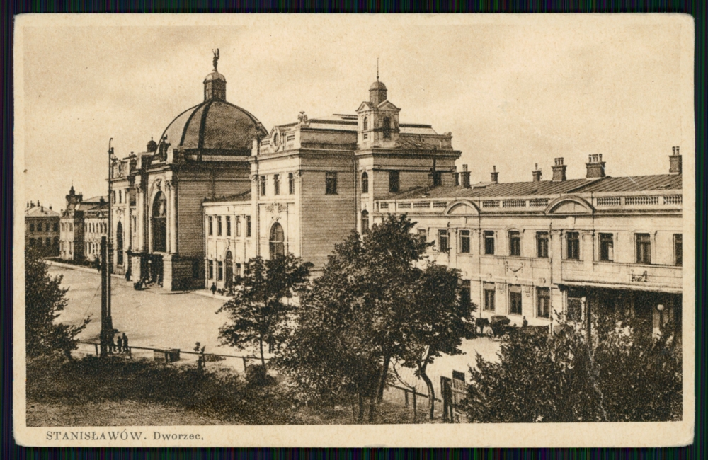 Na zdjęciu widoczny jest dworzec kolejowy w Stanisławowie. Centralna część budynku jest wyższa niż reszta i ma stożkowaty kształt dachu.