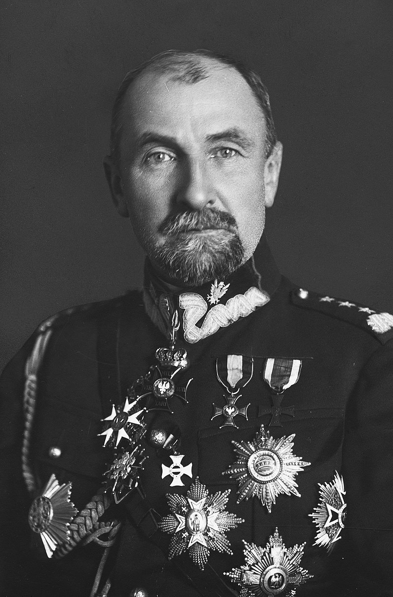 Jest to zdjęcie portretowe mężczyzny w mundurze Wojska Polskiego. Jest odznaczony kilkoma orderami. Na lewym ramieniu jest widoczny stopień wojskowy generała broni: trzy gwiazdki i taśma.